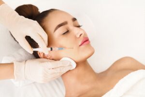 Woman closes her eyes during a Juvederm® injection as she thinks about how to maximize filler longevity