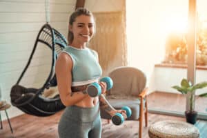Woman lifting weights to maintain muscle during medical weight loss